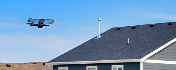 Inspection drone flying near a residential shingle roof to assess condition and check for damage