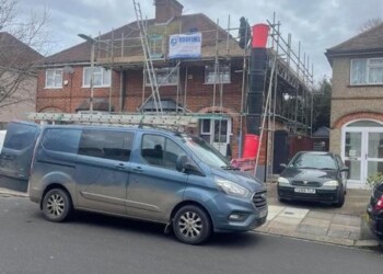 FJ Roofing branded work van parked in front of a residential house undergoing roof replacement with scaffolding