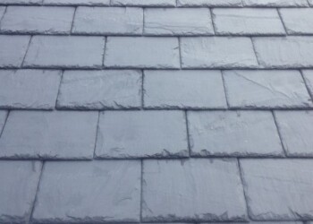 Close-up view of dark natural slate roof tiles laid in a traditional overlapping pattern.