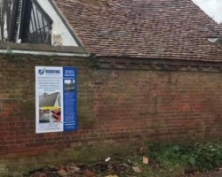 Professional roofer repairing damaged clay roof tiles on a traditional pitched residential roof.