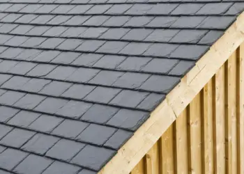 Dark grey slate roof tiles neatly installed on a wooden framed structure or outdoor shed.